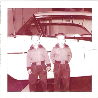 Vintage photograph of two boys standing beside a car